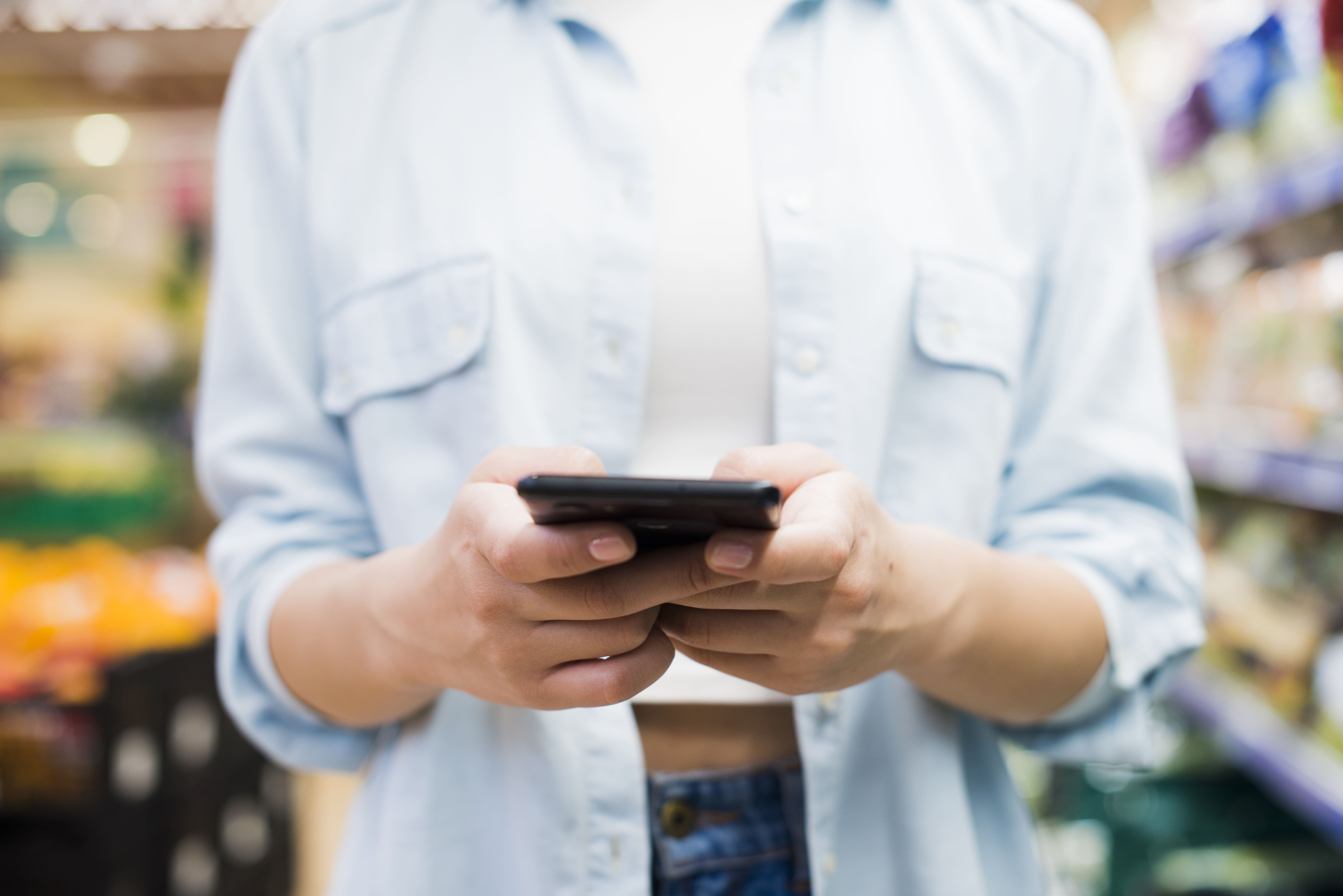 woman-browsing-smartphone-grocery-store (1)